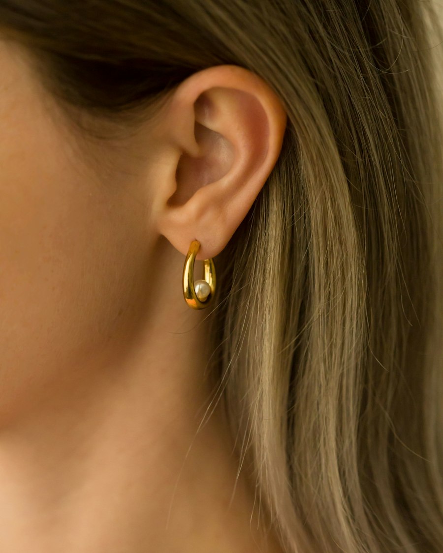 Close de orelha com brinco dourado