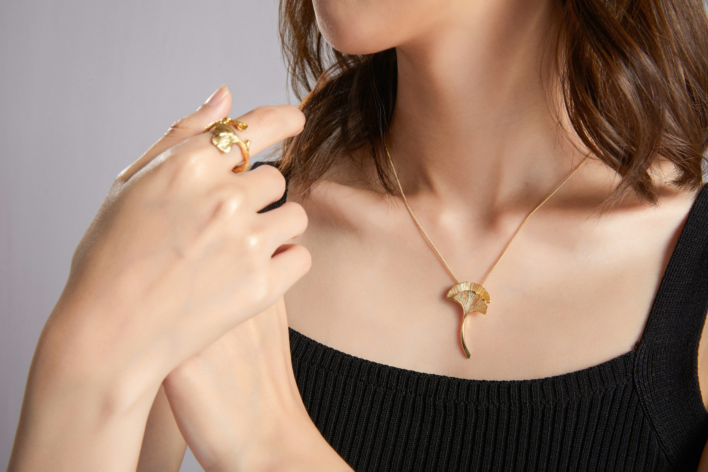 Mulher de blusa preta usando colar dourado