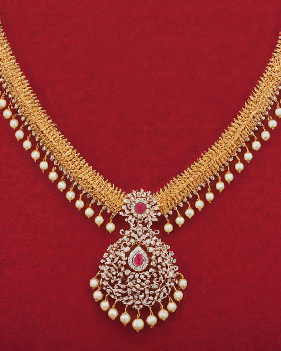 Colar dourado com pérolas sobre fundo vermelho