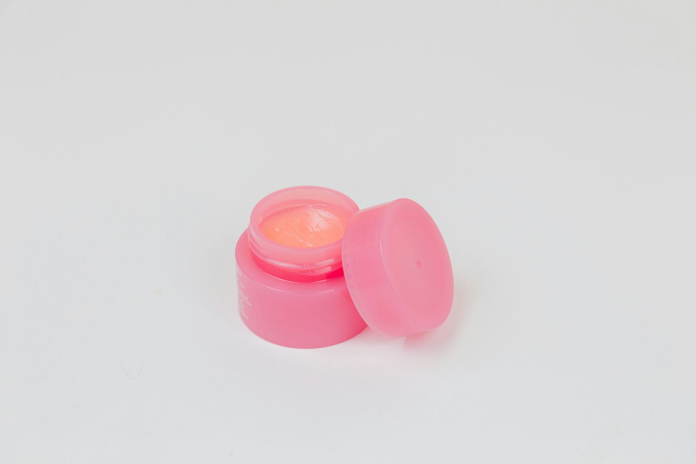Pote rosa de tampa redonda sobre fundo branco